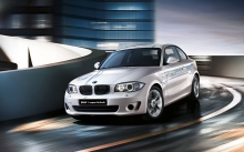 Блестящий белый BMW 1 series ActiveE спускается с эстакады